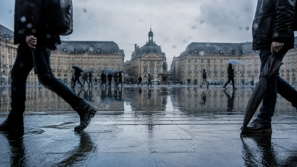 Visiter bordeaux sous la pluie, place de la Bourse : parapluies et pavés mouillés